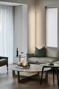 A minimalist living room featuring marble coffee tables and a leather sofa.
