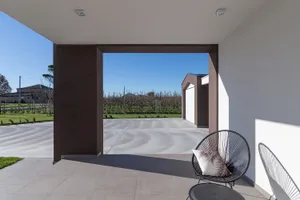 Concrete driveway with modern furniture and a blanket.