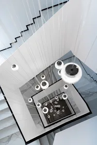 A minimalist modern interior featuring large glass light fixtures hanging from the ceiling.