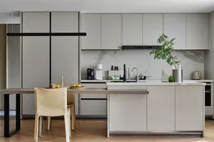 A modern kitchen with a marble countertop and matte-finished cabinets.