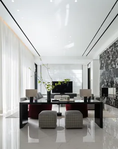 Modern living room featuring marble and glass materials with contemporary furniture and a large television.