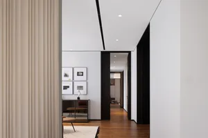 A modern living room featuring a wooden floor, glass walls, and concrete elements.