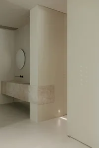 A modern minimalist bathroom with marble finishes and sleek, contemporary fixtures and fittings.