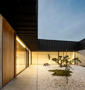 Modern residential entryway featuring concrete floor and glass walls.