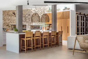 A modern residential kitchen with wooden furniture and flooring.