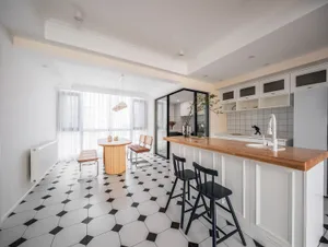 Modern residential kitchen featuring a wooden island and black and white patterned tiles on the floor.