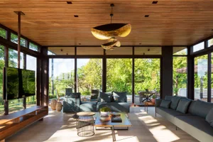 A modern living room featuring a wood floor, large windows, and a comfortable seating area.
