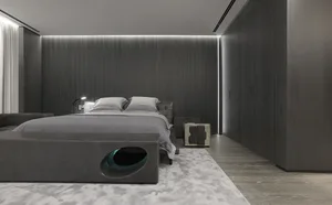 Modern minimalist bedroom with grey walls, wooden floors, and a grey bedspread.