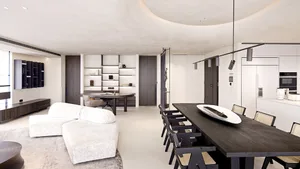 Modern minimalist living, dining, and kitchen space in a modern home with white and wooden finishes.