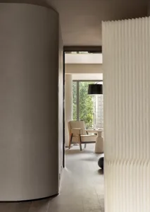 Modern minimalist living room featuring a white curtain and column.