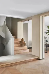 Modern interior design featuring a staircase with wooden steps and floor, accompanied by a wall-mounted vase.