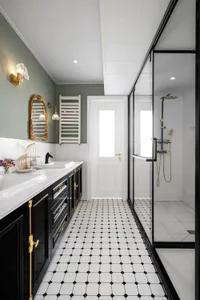 Modern minimalist bathroom featuring white and black floor tiles with a glass shower enclosure.