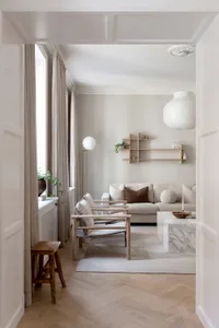 A minimalist living room featuring neutral-toned furniture and decor.