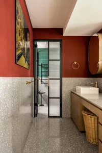 Modern bathroom featuring a terrazzo floor and walls with a glass door.