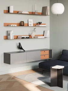 A modern living room with floating shelves on the wall, a dark blue sofa, and a black side table.