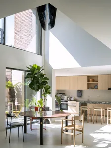 Modern kitchen and dining area featuring marble countertops and wooden furniture.