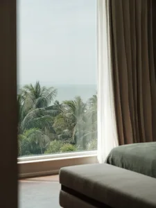 A view of a modern residential interior showcasing textured curtains and a serene ocean view.
