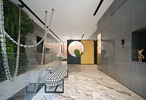 A modern living room featuring marble flooring and a unique decorative element made of metal chains hanging from the ceiling.