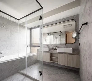 Modern minimalist bathroom featuring marble walls and floor, glass shower enclosure, and double sink vanity.