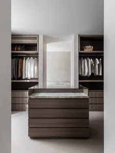 Modern minimalist closet with wood cabinets and marble countertop and shelves.