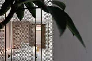 A modern living room with textured wallpaper, featuring a sleek sofa and contemporary decor.