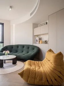 A modern minimalist living room featuring a white textured cushion and yellow-green couch, with white walls, wood flooring, a