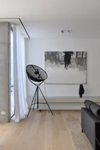 Modern living room featuring a concrete bench, wooden floor, and a black floor lamp.