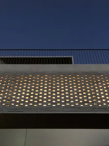 Modern building exterior with integrated lighting in a grid pattern on a concrete facade.
