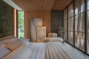 A modern bedroom with white bedding, wooden walls, and marble accent.