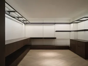 Modern closet with wooden cabinets and steel railings.