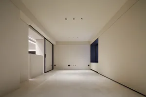 An empty minimalist interior space featuring concrete walls and floor.