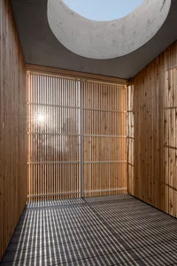 Sunlight streaming through wooden lattices in a minimalist interior space