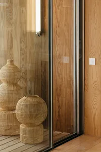 Modern bathroom featuring wooden paneling with a glass sliding door.