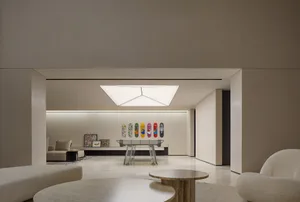 Modern minimalist living room with white furniture and geometric light fixture.