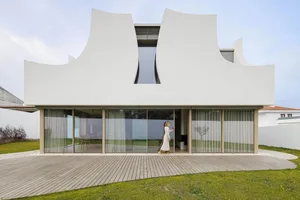 A modern residential building with a white cement exterior.