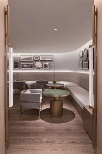 A modern restaurant-cafe with neutral textiles, bronze tables, and glass-top tables.