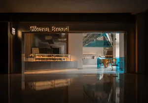 A modern cafe with a large window, seating areas, and natural light
