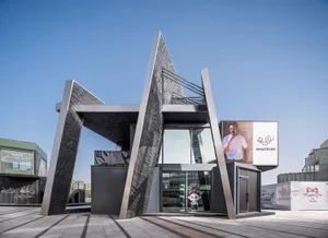 Modern building with a metal structure, glass facade, and natural light illuminating the interior spaces