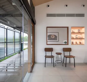 兩把椅子與花瓶打造出展廳內舒適的座位區，搭配鏡子與溫馨氛圍