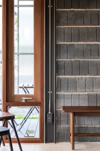 Cozy dining area with brick walls, multiple tables, and chairs, creating a warm atmosphere for socializing