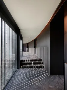 A black and white hallway with a staircase leading to another level, featuring two sets of steps and a sense of depth and dimension