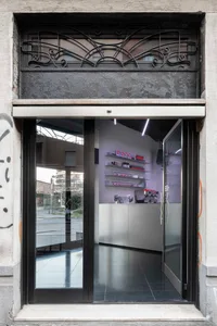 A well-maintained hair care store with glass shelves, multiple bottles, and a large mirror on one wall