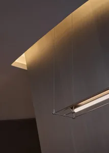 A modern building interior with a striking ceiling featuring hanging lights, clean lines, and a monochromatic color scheme, with steel as the primary material