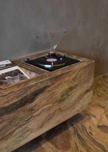 A cozy living space with a wooden table, a record player, and scattered books, evoking a nostalgic atmosphere