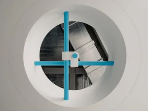 A round window with a blue object in its center, set against a background that suggests an interior design or art installation