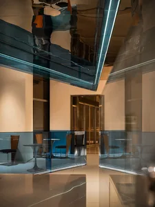 Bright modern restaurant with glass walls, dining tables, and chairs, featuring natural light and a contemporary atmosphere