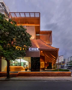 A warm and inviting cafe with a curved wooden roof, brick exterior, and interior furniture and decor