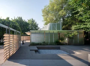 A modern house with a large glass wall, wood and glass elements, and abundant natural light