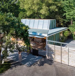 一座帶有大型木製屋頂的露天涼亭，周圍人們社交互動，享受悠閒氛圍