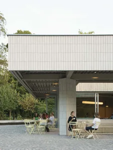 Outdoor dining area with tables, chairs, and patrons enjoying meals in a relaxed atmosphere